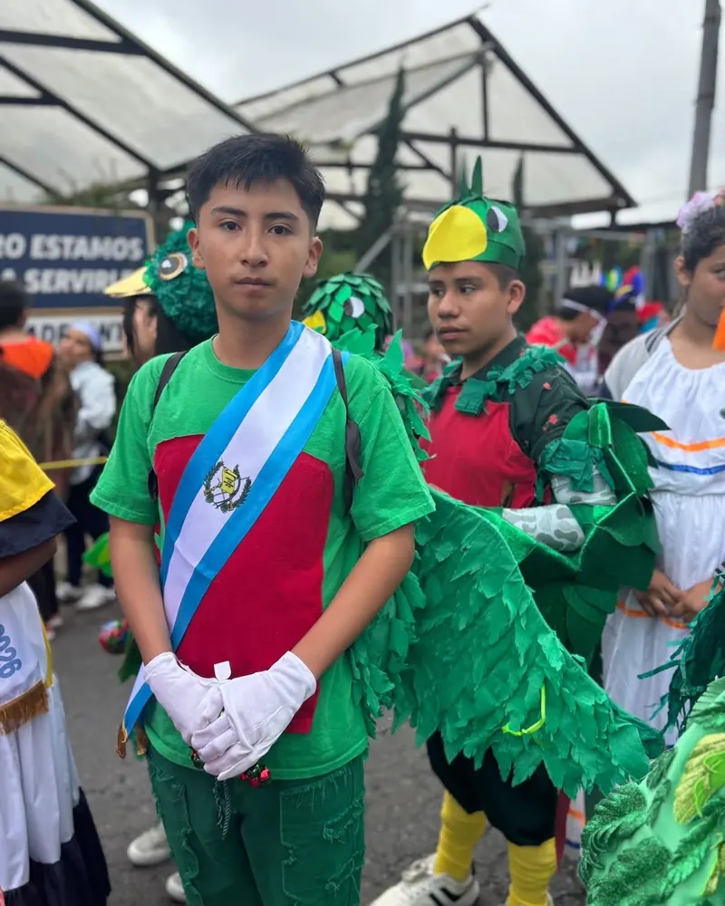 Estudiante con banda de Guatemala y traje inspirado en el quetzal